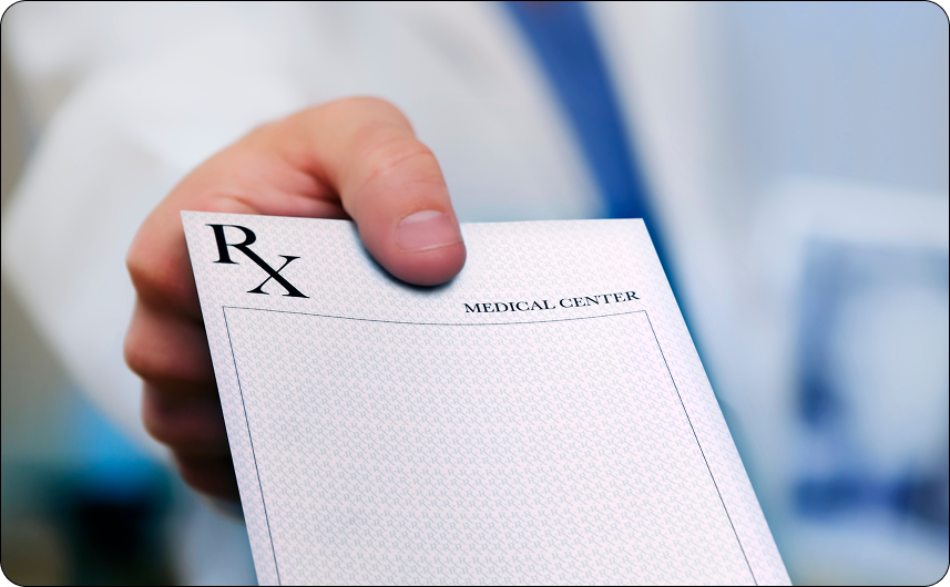 Hand holding a prescription pad with 'RX' symbol, blurred background